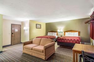 Pokój hotelowy z 2 łóżkami i krzesłem w obiekcie Econo Lodge Lansing - Leavenworth w mieście Lansing