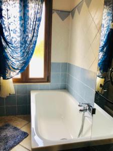 a bath tub in a bathroom with a window at Bla Bla House Alghero-Olmedo in Olmedo