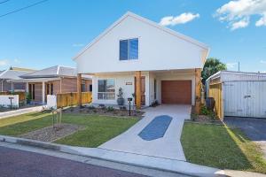 a white house with a gate and a driveway at Accommodation Hunter - James Street Morpeth in Morpeth