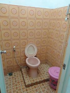 uma casa de banho com um WC rosa num quarto em Wisma Kahyangan em Baubau