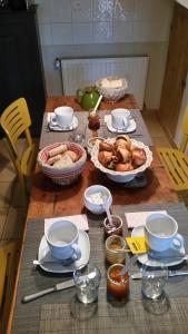 clos st Joseph في أولينز: طاولة عليها صحون وأوعية طعام