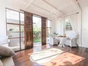 烏魯瓦圖的住宿－Mangga Wangga Living，客厅配有桌椅和窗户。