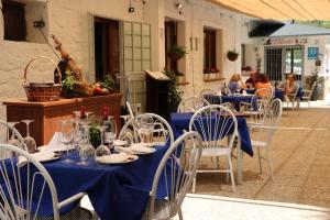 een groep tafels en stoelen met blauwe tafelkleden bij Hotel El Guerra in Güéjar-Sierra