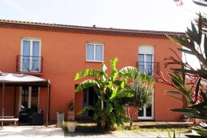 een oranje gebouw met ramen en planten ervoor bij T3 L'Olivier & Jardin 1 à 4 Pers à Villa Terra in Balma