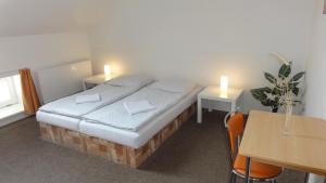 1 dormitorio con 1 cama y 1 mesa con 2 velas en Penzion U Hradeb en Znojmo