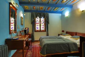 een slaapkamer met 2 bedden, een bureau en een raam bij Royal Ricc in Brno