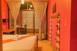 a bedroom with a bed and a large window at Boutique House Nipha in Chiang Mai