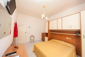 een slaapkamer met een bed, een bureau en een televisie bij Hotel Da Italo in Seccheto