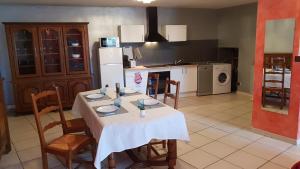 een keuken met een tafel met een witte tafeldoek bij Les Barons de Guers in Castelnau-de-Guers