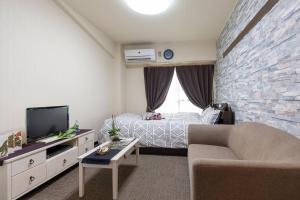 a small living room with a bed and a couch at Cozy house K46, free wifi a rented electric bicycle in Kyoto