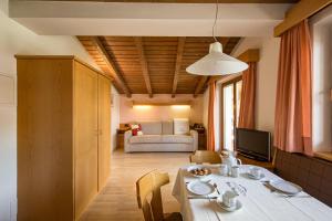 - un salon avec une table et un canapé dans l'établissement Residence Sas Vanna, à La Villa