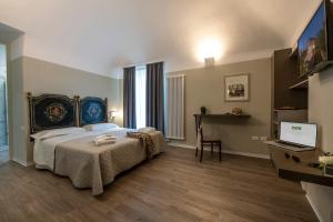 a bedroom with a bed and a desk with a laptop at RESIDENZA DON ALBERTO in Ornano Grande