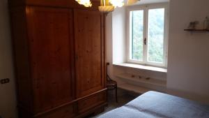 een slaapkamer met een grote houten kast en een raam bij La Casalina dell'Elba in Marciana