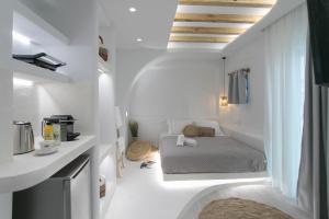
a hotel room with a white bed and white walls at Majestique of Naxos in Naxos Chora
