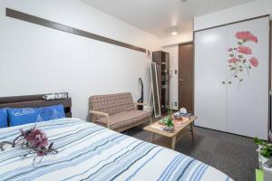 a bedroom with a bed and a chair and a table at Cozy house 305 free wifi a rented electric bicycle in Kyoto