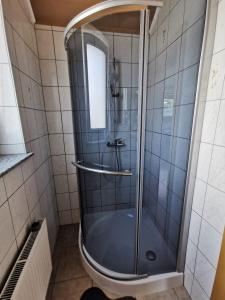 W łazience znajduje się prysznic ze szklanymi drzwiami. w obiekcie Pohorje w mieście Spodnje Hoče