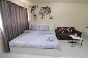 a bedroom with a bed and a couch at ป๊อปปูล่า คอนโด อาคาร C4 impact เมืองทองธานี in Nonthaburi