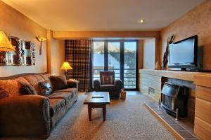 a living room with a couch and a television at Shoshone Condos at Big Sky Resort in Big Sky
