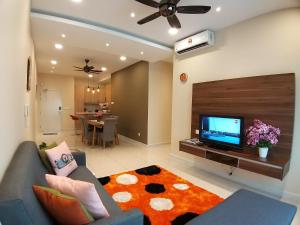 uma sala de estar com um sofá e uma televisão de ecrã plano em Southville Stay @ Savanna Executive Suite em Bangi