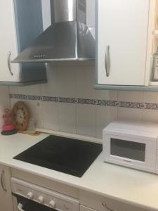 a kitchen with a stove top oven and a microwave at Torrox costa apartamento in Torrox Costa