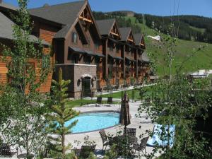 a resort with a pool in front of a building at Big Sky Resort Village Center in Big Sky