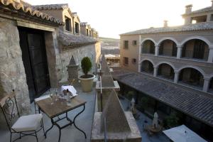 an outdoor patio with tables and chairs and buildings at HOTEL PALACIO DE MENGIBAR in Mengibar