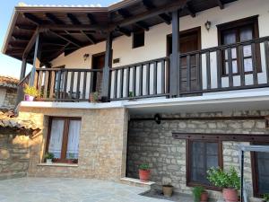 a house with a balcony and a patio at Guest House Genti in Berat