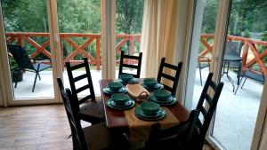 a dining room table with chairs around it with a balcony at Domek Gościnny Dyziówka in Szczyrk