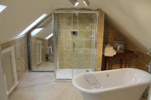 a bathroom with a shower and a bath tub at Drake Cottage in Whitby