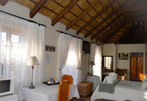a bedroom with two beds and a table and a window at Cheetau Lodge in Ebenhaezer