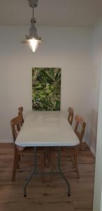a white table with two chairs and a painting on the wall at Im Dobbenviertel mit Terrasse 3 Doppelzimmer 98qm in Oldenburg