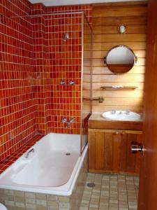 a bathroom with a tub and a sink at Retro 2 Bedroom Apartment in Thredbo