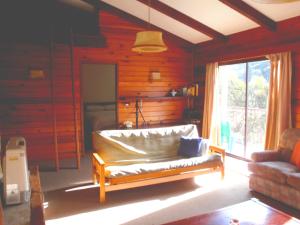 a living room with a couch and a window at Retro 2 Bedroom Apartment in Thredbo