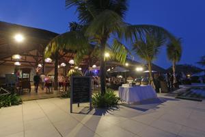 a restaurant with a table and palm trees at night at Peninsula Beach Resort in Nusa Dua