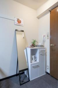 uma pequena cozinha com um espelho e um frigorífico em Cozy house 8, free wifi a rented electric bicycle em Quioto