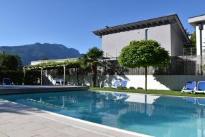 a swimming pool with chairs and a house at Villa Dina in Riva del Garda