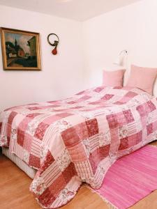 a bedroom with a bed with a red and white quilt at Ebeltoft Midtby in Ebeltoft