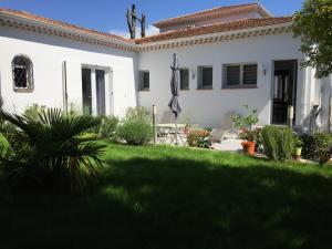 a white house with a yard with a green lawn at Terreazur in Mandelieu-la-Napoule