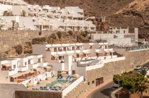 a group of white buildings on a hill at Granada II Apartments in Puerto Rico de Gran Canaria