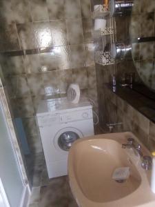 een badkamer met een wasmachine en een wastafel bij Magrignano in Montieri