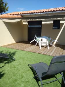 a deck with two chairs and a table on a house at Au refuge des farfas in Saint-Paul-en-Pareds