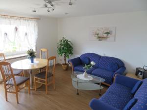 ein Wohnzimmer mit einem blauen Sofa und einem Tisch in der Unterkunft Gästehaus Huber Meersburg in Meersburg