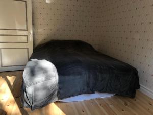 łóżko w pokoju z czarną przykrywką w obiekcie Nedanby | Cottage | Idyllic location | Porch | Grill w mieście Edsbro