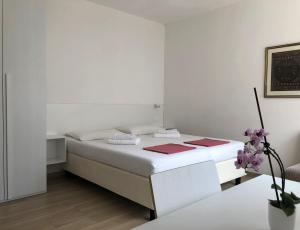 a white bedroom with a bed and a table at Villa Dina in Riva del Garda +79 photos
