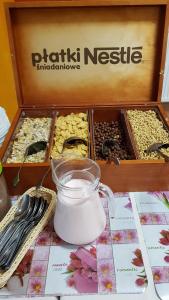 una caja de nueces y un frasco de leche junto a una taza en O.W. Krakus II - Domki i Pokoje en Stegna