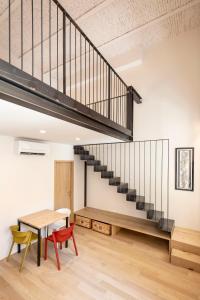 a loft with a staircase and a table and chairs at Design Loft Corte Kalister in Trieste