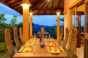 a long wooden table with chairs on a patio at Villa Rosa in Kandy