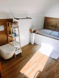 La salle de bains est pourvue d'une baignoire, de toilettes et d'un lavabo. dans l'établissement Beskidzki Domek, à Kurów
