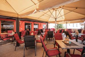 restauracja ze stołami, krzesłami i parasolami w obiekcie Gasthof Zellerstuben w mieście Zell am Ziller