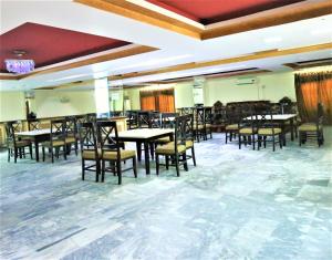 a dining room filled with tables and chairs at Tourist Inn Hotel in Lahore